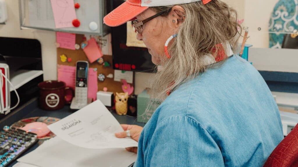 West Tulsa Tag Agency staff member reviewing Oklahoma vehicle registration paperwork and documents for fast, accurate processing.